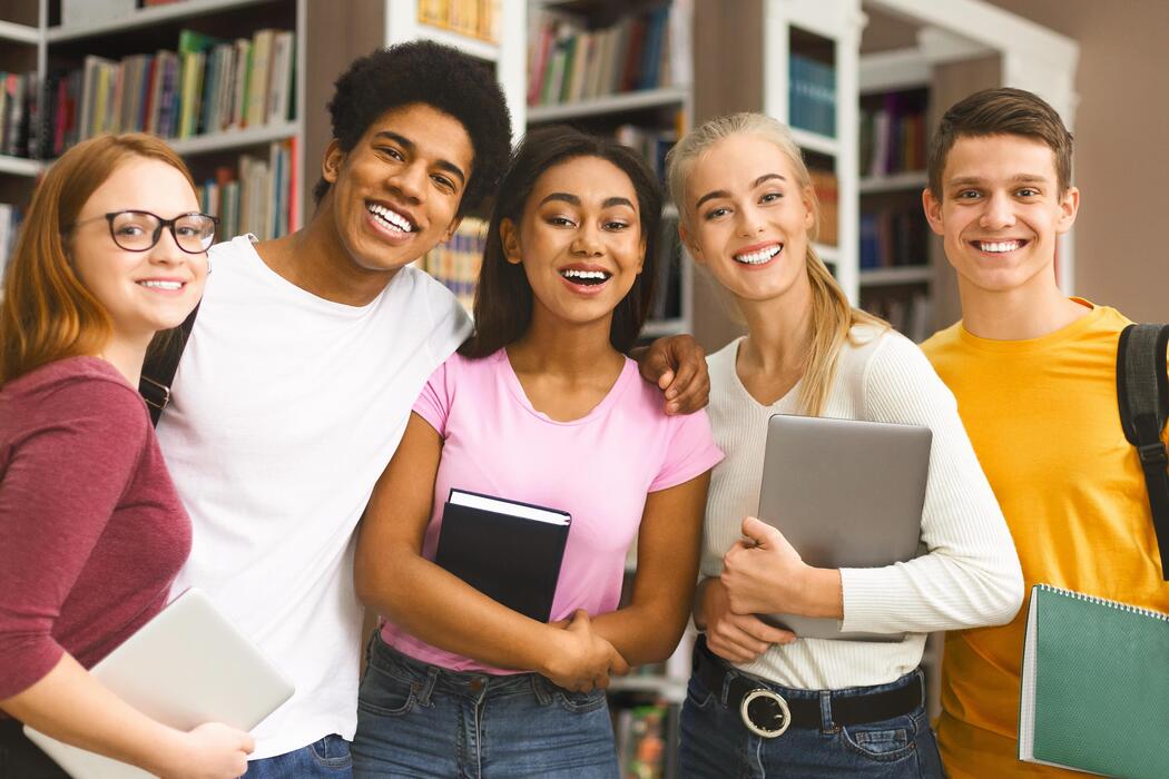Happy diverse international students smiling together at university library